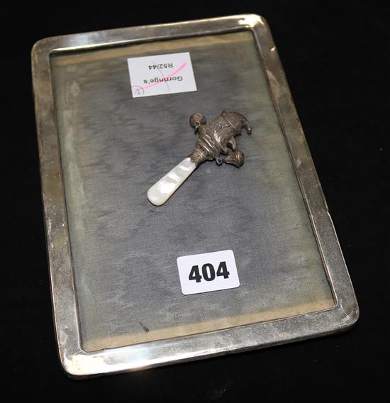 A silver photograph frame and a silver Mr. Punch childs rattle.